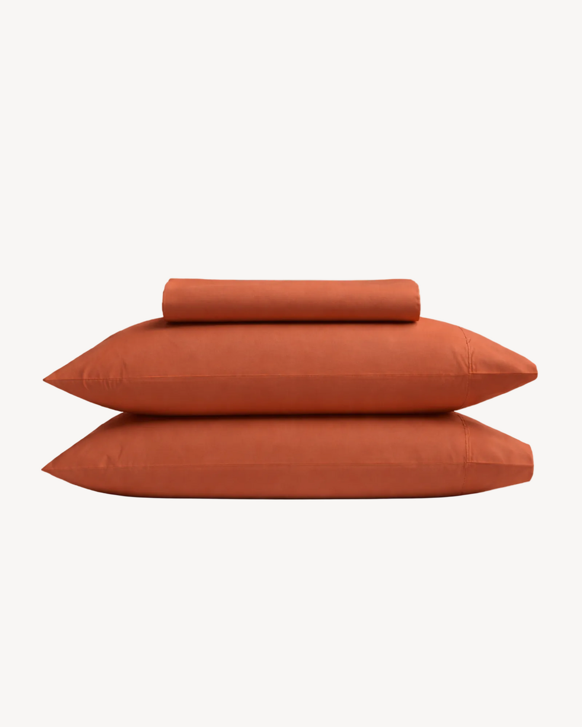 A folded terracotta fitted sheet with two matching pillowcases